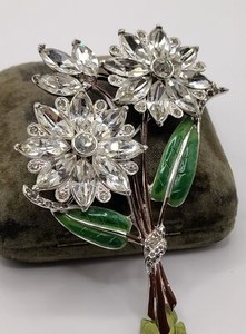 Large clear rhinestone floral spray brooch with green enamel leaves