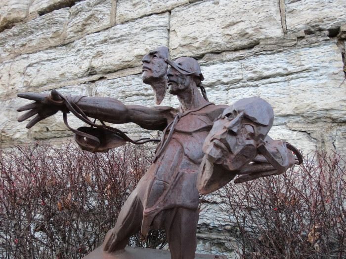 Theodore Gall Number Three Man corten steel sculpture against a stone wall
